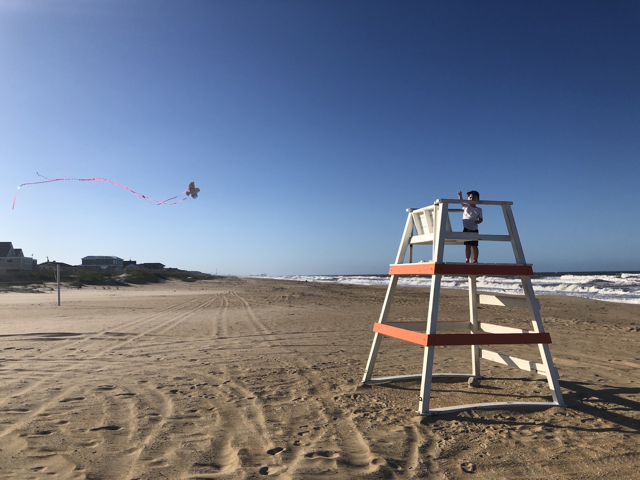 Child on lifeguard stand with kite flying on Sandbridge Beach