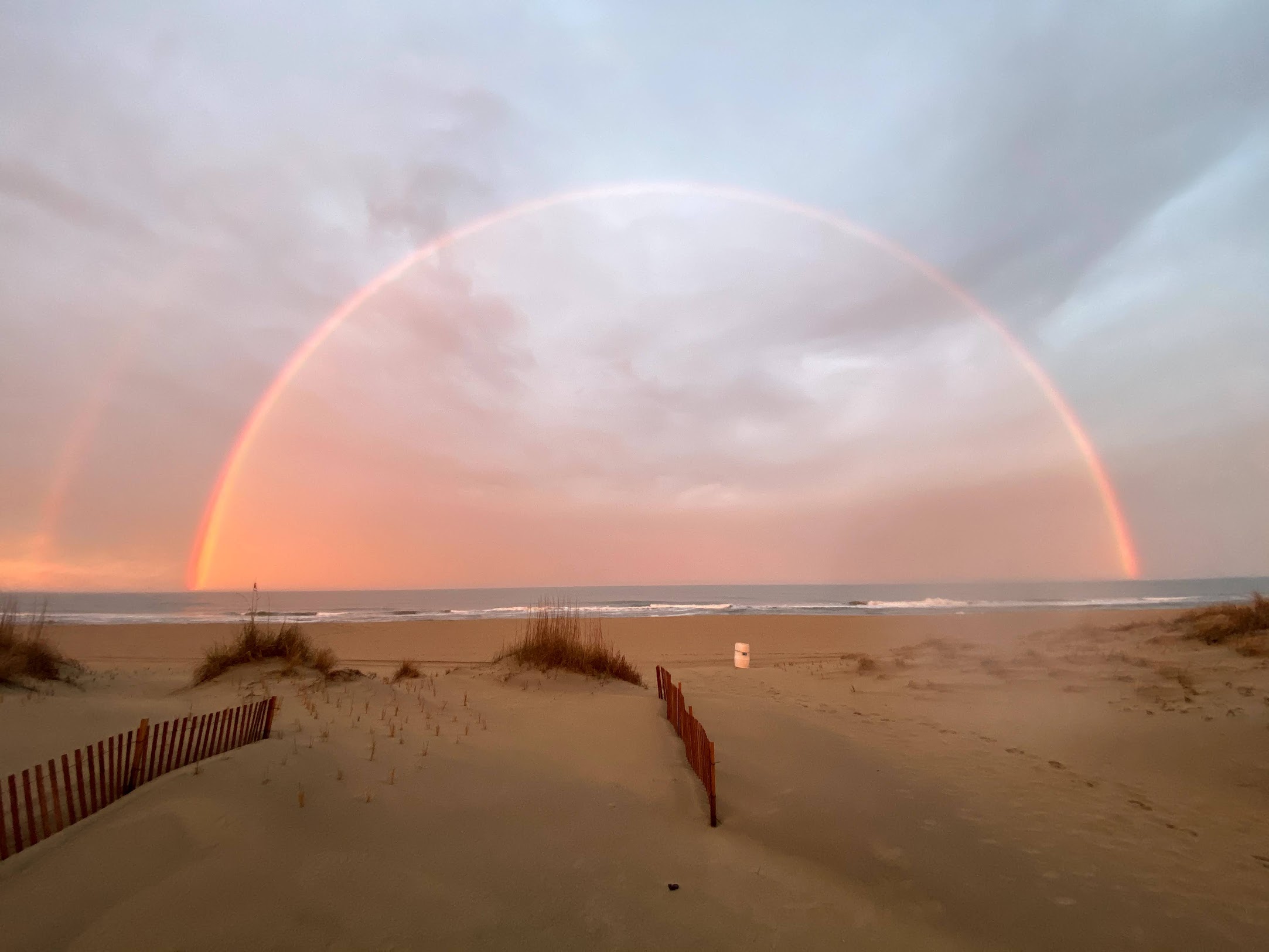 Rainbow over Sandbridge Beach dunes at sunset